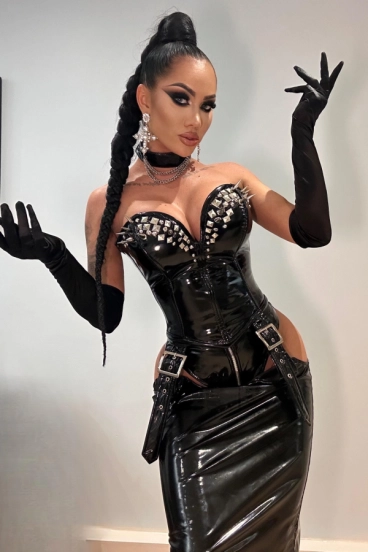 A very sexy brunette dominatrix in a black latex outfit