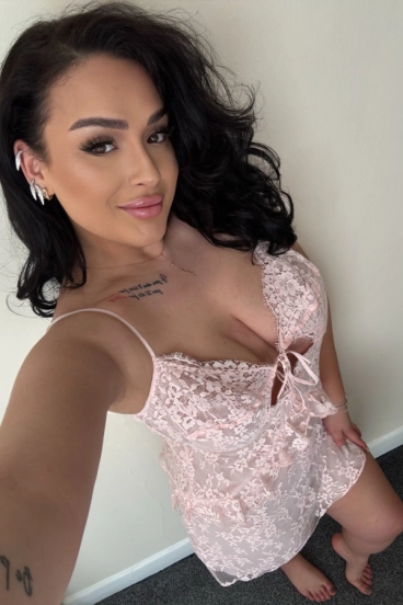 Busty brunette London escort wearing a very low cut night dress