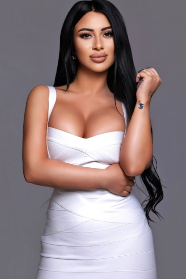Elegant brunette busty London escort in white figure-hugging dress