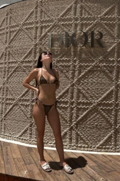 Erika is standing by a pool side sign and looks very hot 