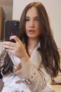 A very sexy mirror selfie of Dalia wearing a rain mac 
