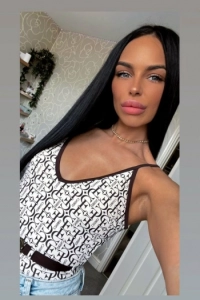 Sexy selfie of brunette escort Shanel wearing a white top 