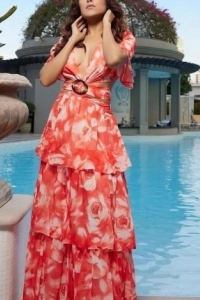 Ananya standing by a pool in a red dress 