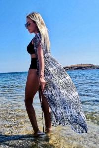 Standing in the sea and looking very elegant is blonde mature escort Ana