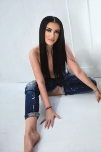 Erina is sitting on the floor wearing dark blue jeans