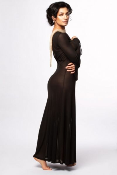 A very elegant brunette high class London escort is wearing a long black dress 
