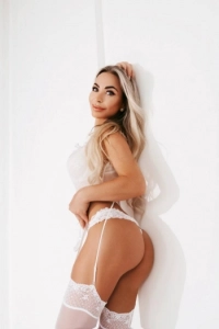 Sexy blonde lady against a white back ground wearing white lingerie 