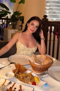 Sexy lady sitting at a dinner table 
