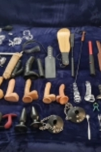 Various sexy toys laid out on a bed 
