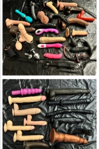 Sex toys on a black sheet on a bed 