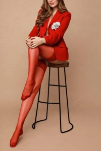 Anora is sitting on a stool 
