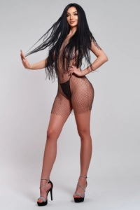 Slim busty escort dressed in a mesh basque 