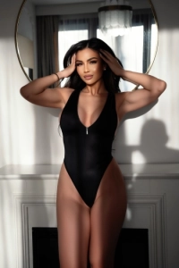 Busty brunette lady wearing a black swim suit 