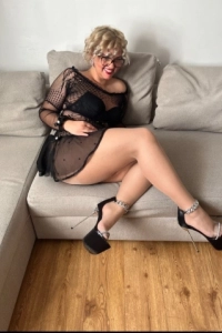 Phoenix has red lips in this picture of her sitting on a sofa 