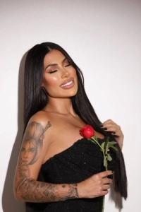 A brunette woman holding a red rose 