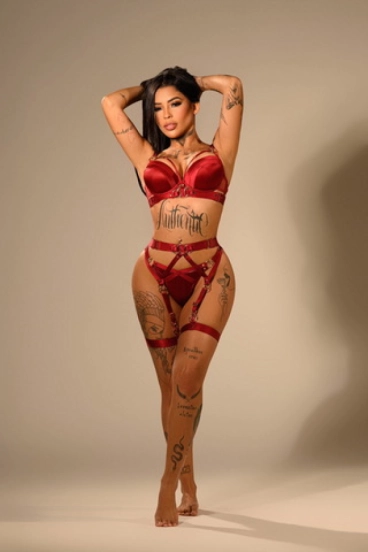 Elegant Brazilian escort Bruna in red lingerie, alluring confidence and graceful pose