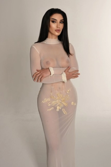 Brunette Russian escort wearing a white see through dress 