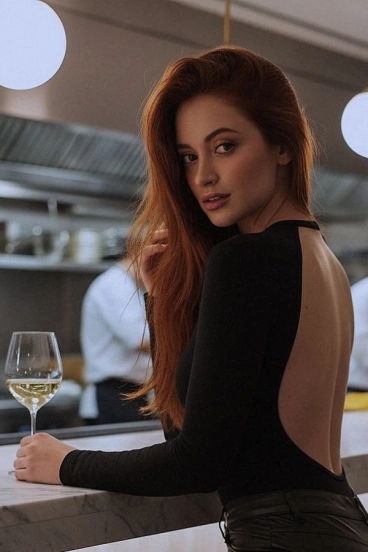 Beautiful red head escort ordering a drink 