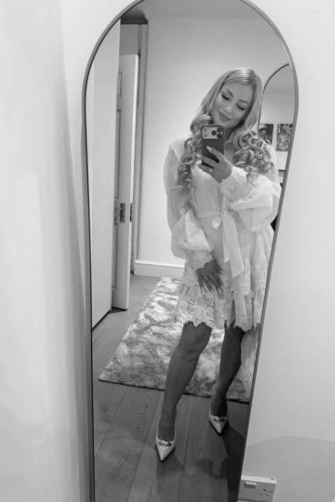 Verity is posing for a selfie in a full length mirror 
