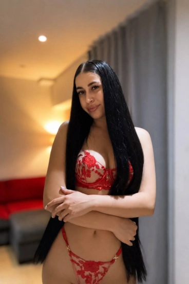 Busty brunette escort Aliya wearing a red bra 