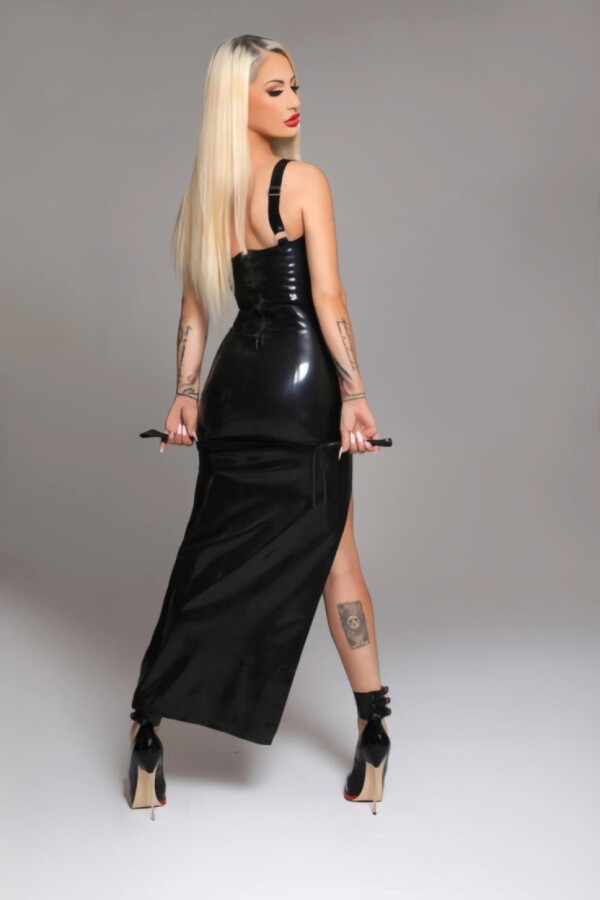 Beautiful blonde dominatrix wearing a long black dress