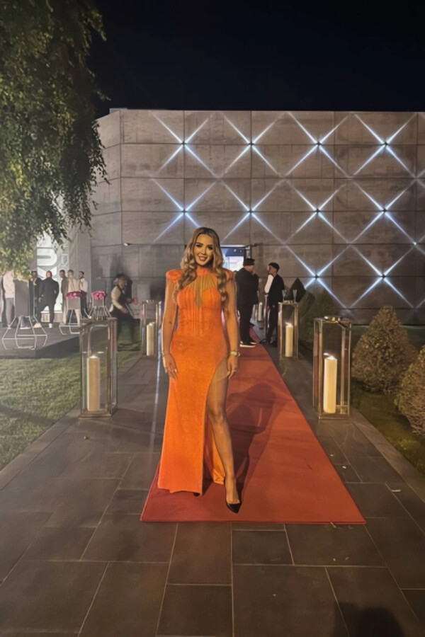 Martini loks very sexy wearing a long orange dress