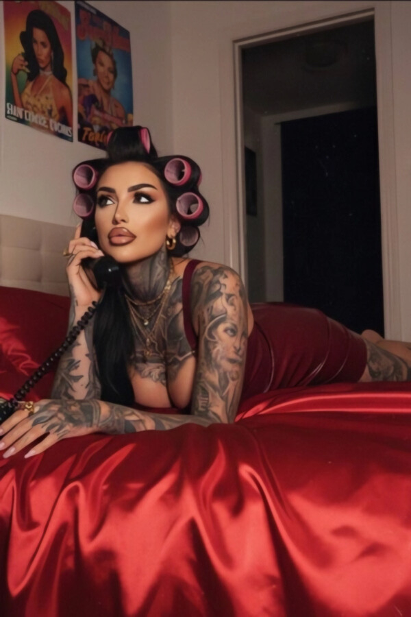 Heavily tattooed brunette lady laying on her bed