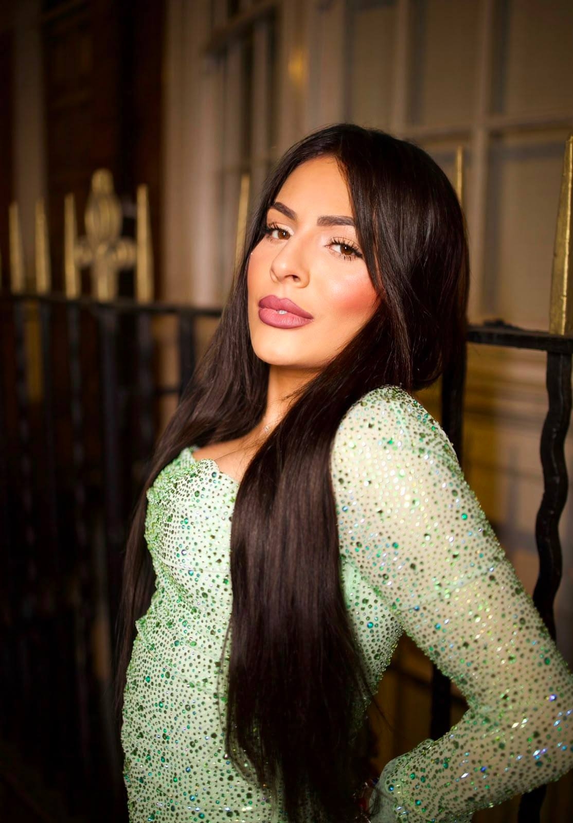 Aline in a close portrait wearing a sparkling green dress with long dark hair