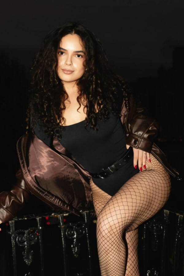 A pretty brunette woman wearing a basque teamed with fishnet tights