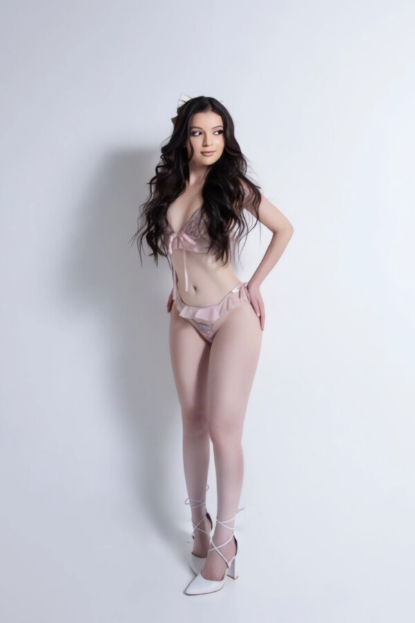Young brunette lady wearing light pink lingerie