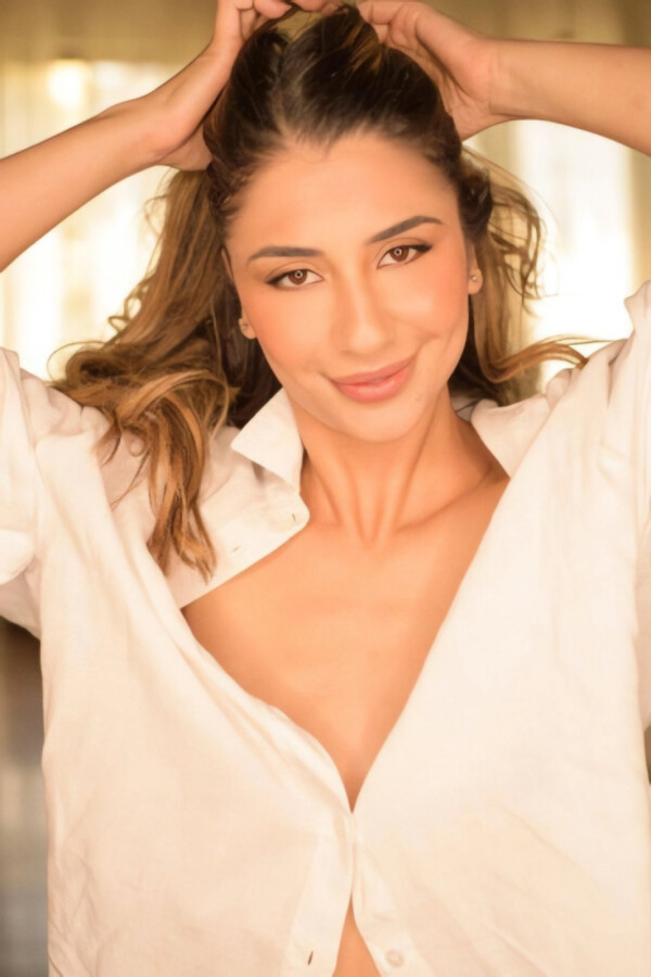 Kimberly wearing an oversized white shirt with long highlighted hair