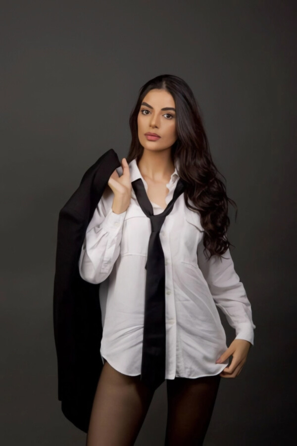 A lady wearing a white shirt and tie
